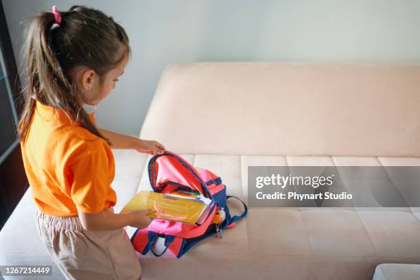 primary school student preparing the backpack - satchel stock pictures, royalty-free photos & images