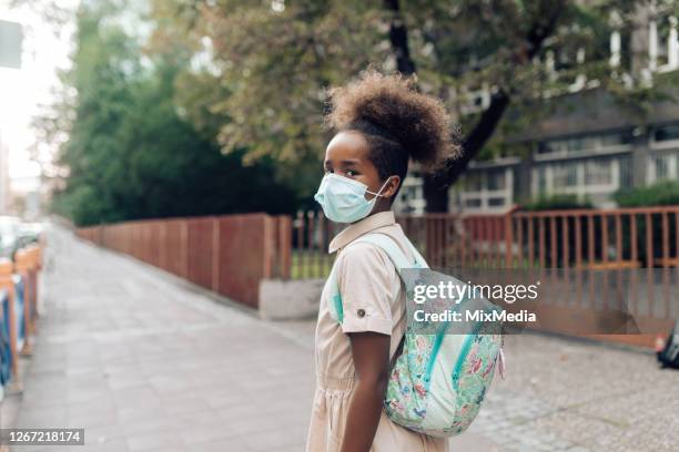 chica con una mascarilla protectora que va a la escuela - contaminación del aire fotografías e imágenes de stock