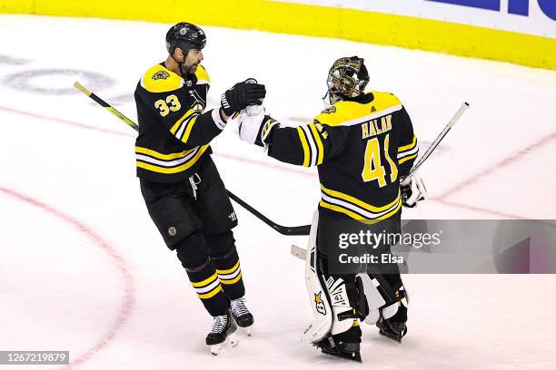 Zdeno Chara and Jaroslav Halak of the Boston Bruins celebrate their teams 2-1 win against the Carolina Hurricanes in Game Five of the Eastern...