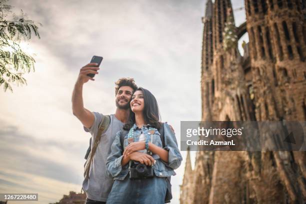 giovane coppia in vacanza che si fa selfie alla sagrada familia - sagrada familia foto e immagini stock