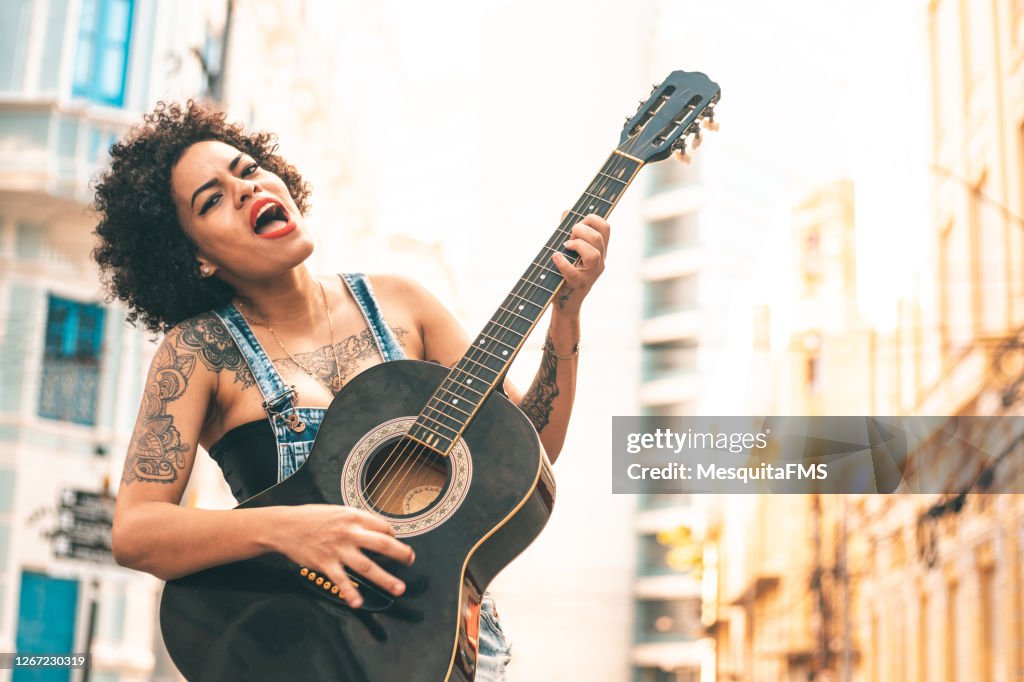 Femme jouant la guitare à l’extérieur