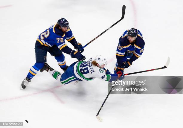 Justin Faulk and Alex Pietrangelo of the St. Louis Blues combine on Adam Gaudette of the Vancouver Canucks during the first period in Game Five of...