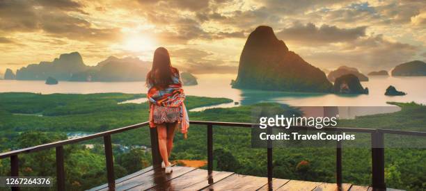 woman wearing dress stand and see the mountain in sunny at the sametnangshe island viewpoint, phang-nga, thailand. - thailand hotel stock pictures, royalty-free photos & images