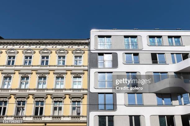 neues wohnhaus neben historischem mehrfamilienhaus in berlin - gentrification stock-fotos und bilder