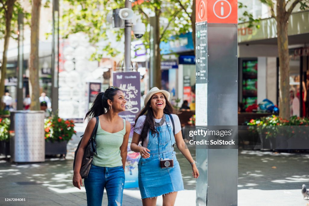 Asiatische Freundinnen gehen die City Street hinunter