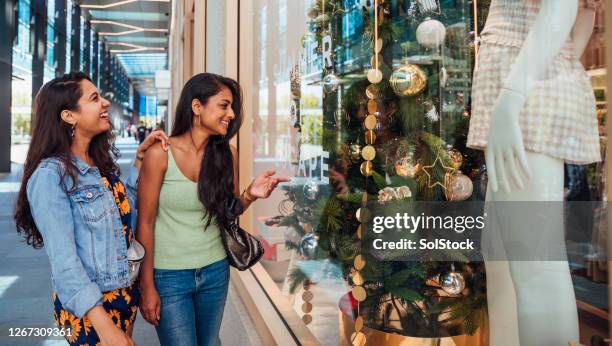 window shopping beslissingen met kerstmis in de zon. - outlet stockfoto's en -beelden