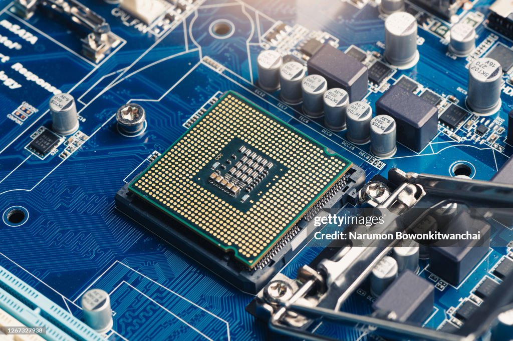 The technician laying the CPU chip in the motherboard's socket