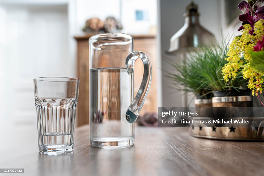 Water glass with carafe on a kitchen table in a kitchen