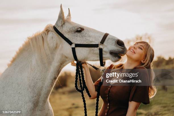 caballo blanco besando joven mujer rubia - 1 woman 1 horse fotografías e imágenes de stock