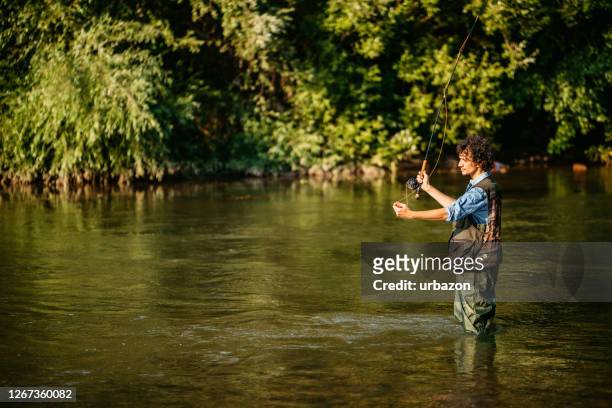 fisherman fishing in a forest river - pike stock pictures, royalty-free photos & images