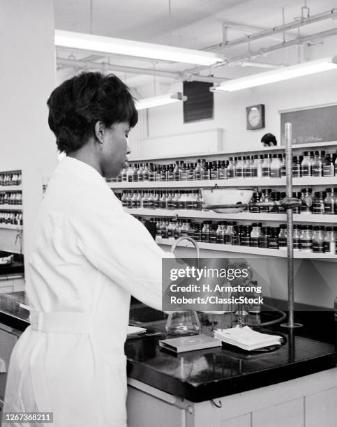 1970s Single African-American Young Woman University College Student In Pharmacology Preparing Medicine In Laboratory