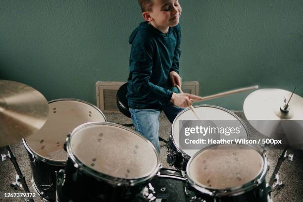 boy playing drums at home - playing drums fotografías e imágenes de stock