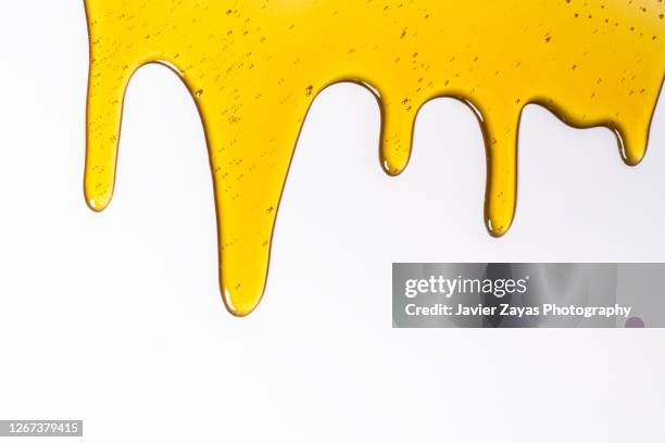 honey on a white colored background - oil flow stockfoto's en -beelden