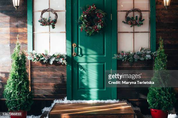 porch with wooden doors and a threshold with christmas decor. - alo house winter - fotografias e filmes do acervo