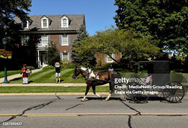 Kutztown, PA A horse and buggy, possibly driven by a Mennonite or Amish person, drives past the protesters on Main Street in Kutztown outside the...