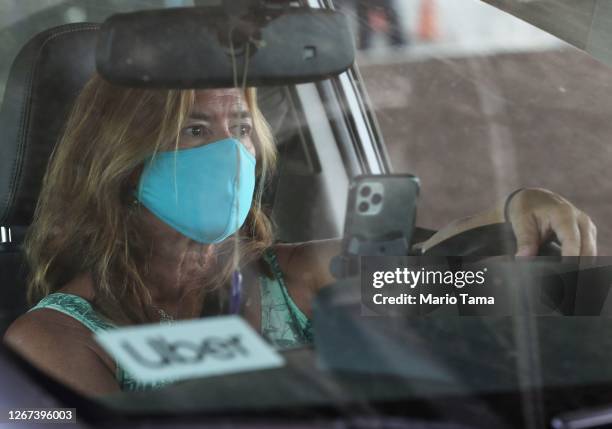 An Uber driver participates in a car rally by Uber and Lyft drivers calling for basic employment rights at Los Angeles International Airport amid the...