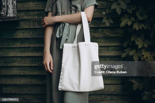 young woman holding white eco bag - reusable bag stock pictures, royalty-free photos & images