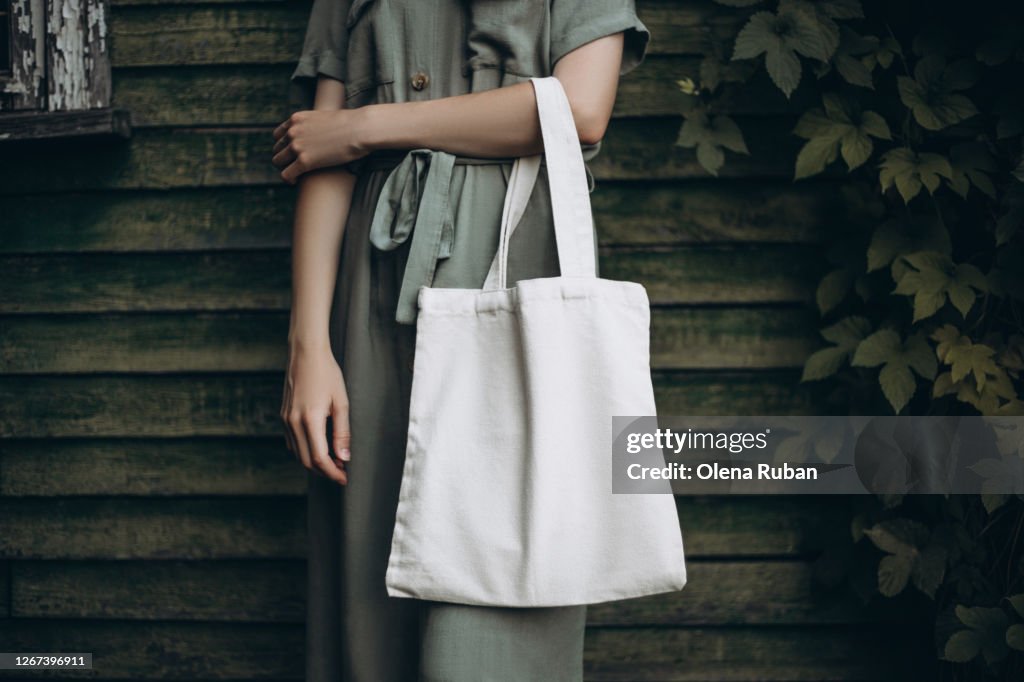 Young woman holding white eco bag