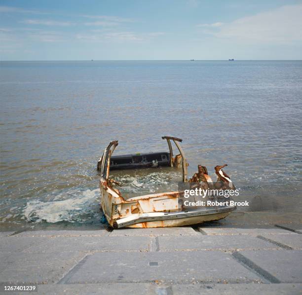 wrecked car in sea at the mouth of the thames estuary, isle of grain, kent, uk - car crash wall stock pictures, royalty-free photos & images