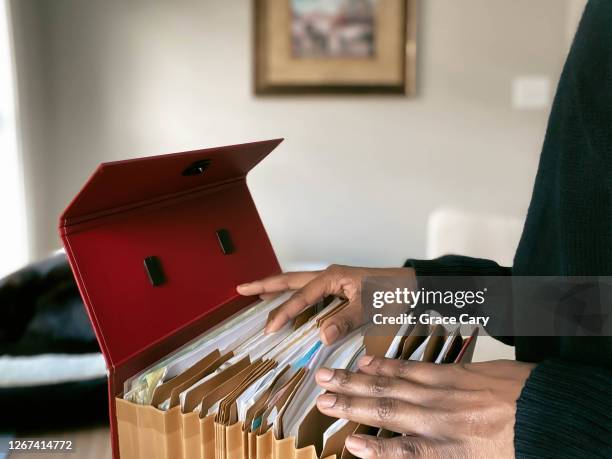 woman searches her files - archivar documentos fotografías e imágenes de stock