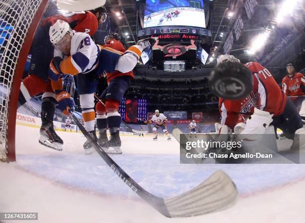 Anthony Beauvillier of the New York Islanders takes a hit from Tom Wilson of the Washington Capitals as the puck goes in the net in the second period...