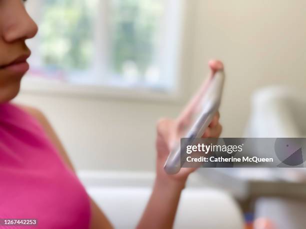 mixed-race teenage girl using her cell phone at home - teenager staring imagens e fotografias de stock