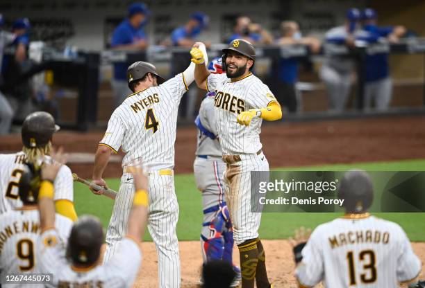 Eric Hosmer of the San Diego Padres is congratulated by Wil Myers after hitting a grand slam during the fifth inning of a baseball game against the...