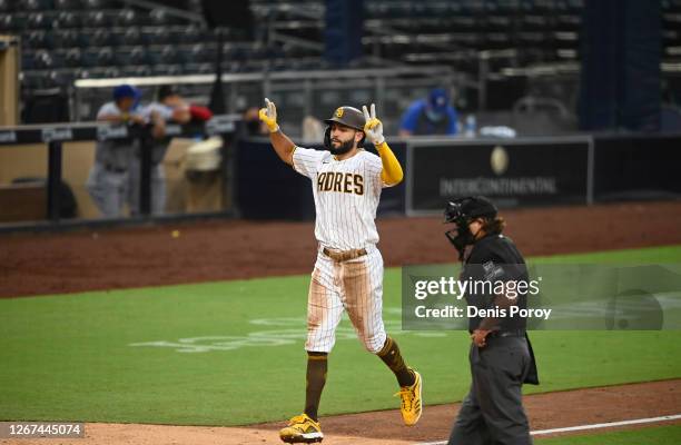 Eric Hosmer of the San Diego Padres points skyward after hitting a grand slam during the fifth inning of a baseball game against the Texas Rangers at...