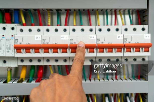 human hand is flipping the power switch in the electrical control cabinet - electrical fuse ストックフォトと画像
