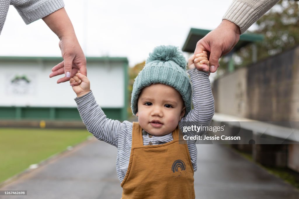 Close up of toddler holding hand with parents