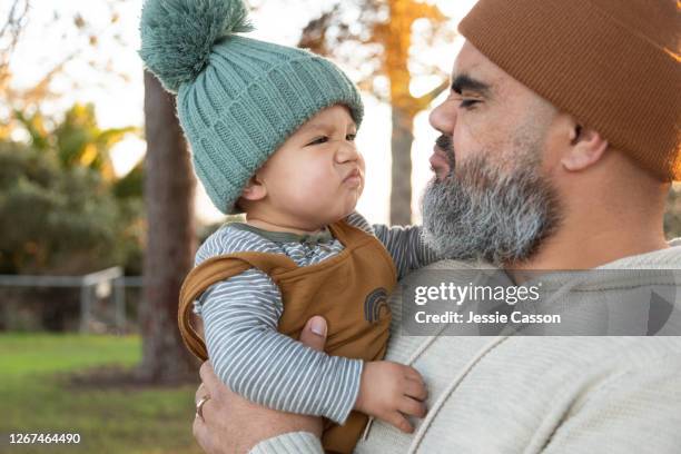 bearded hipster dad and baby pulling funny face - funny face baby stock pictures, royalty-free photos & images