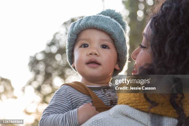 mother holding baby in beautiful light - new zealand yellow stock pictures, royalty-free photos & images