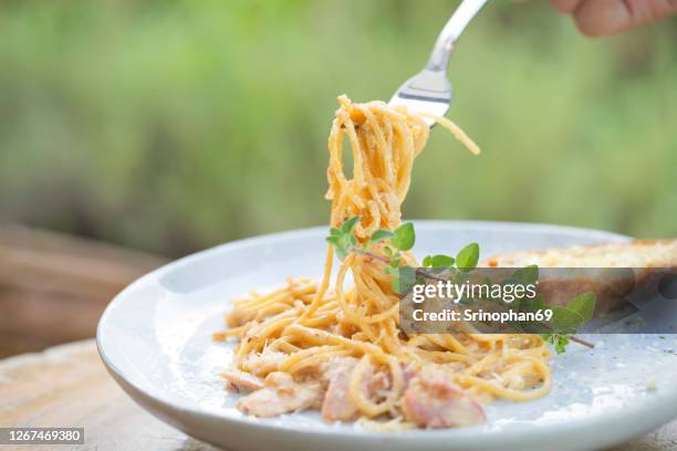 spaghetti with carbonara in a plate on the table - carbonara stock pictures, royalty-free photos & images