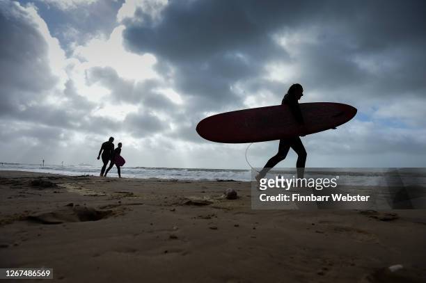 Surfers enjoy the waves at Branksome beach on August 21, 2020 in Bournemouth, United Kingdom. The Met Office extended a weather warning for a further...