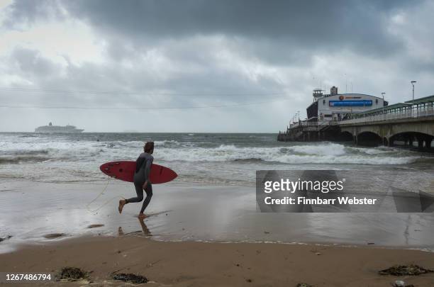 Surfers enjoy the waves at the beach on August 21, 2020 in Bournemouth, United Kingdom. The Met Office extended a weather warning for strong winds a...