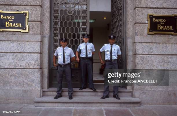 Gardiens d'une société de protection privée surveillant une banque, au Brésil, en novembre 1992.
