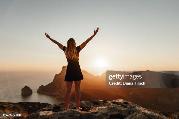 mädchen mit offenen armen vor dem sonnenaufgang - open arms stock-fotos und bilder