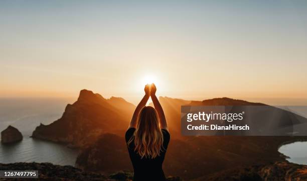 young woman in spiritual pose holding the light - idyllic landscape stock pictures, royalty-free photos & images