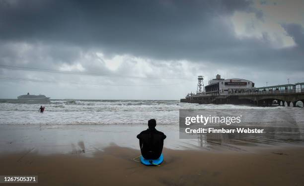 Surfer looks out at the waves at the beach on August 21, 2020 in Bournemouth, United Kingdom. The Met Office extended a weather warning for strong...