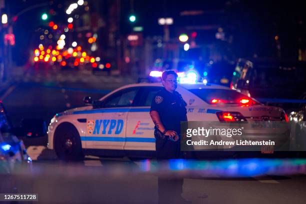 New York City police officers secure and investigate a shooting scene on August 20, 2020 in downtown Brooklyn, New York. Two men got into a fight and...