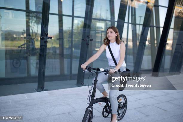 empresaria va a la oficina en bicicleta - foldable fotografías e imágenes de stock