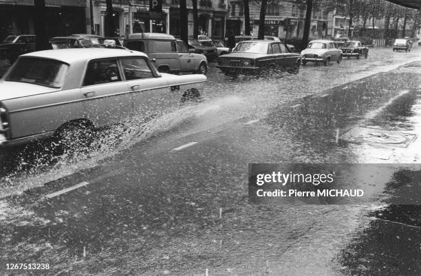 Les éclaboussures d'une voiture roulant dans une flaque, à Paris, circa 1980, France.