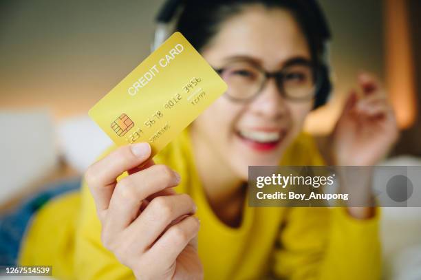 happiness woman holding a yellow credit card in her hand. - holding card stock pictures, royalty-free photos & images