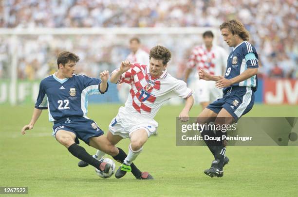 Robert Jarni of Croatia is tackled by Javier Zanetti of Argentina as Gabriel Batistuta looks on during the World Cup group H game at the Parc Lescure...