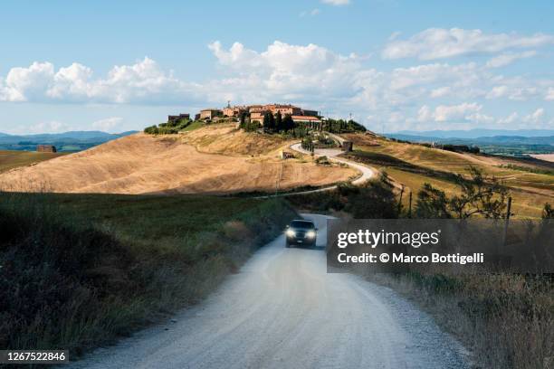 car driving on gravel road in tuscany, italy - driving italy stock pictures, royalty-free photos & images