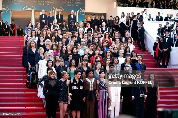 Filmmakers raise their arms as clap after Jury head Cate Blanchett with other filmmakers read a statement on the steps of the red carpet in protest...