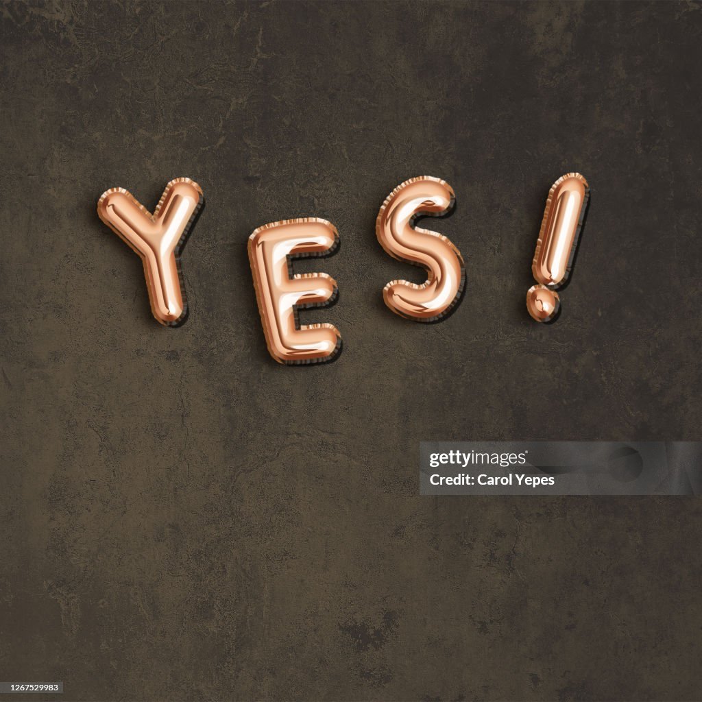 Yes single word in golden foiled balloon and black background