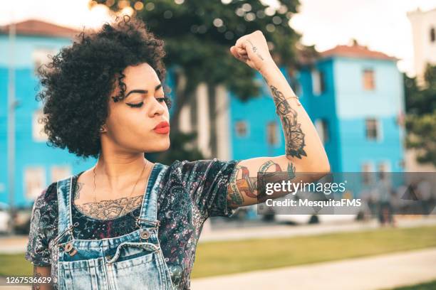 poder femenino - flexionar los músculos fotografías e imágenes de stock