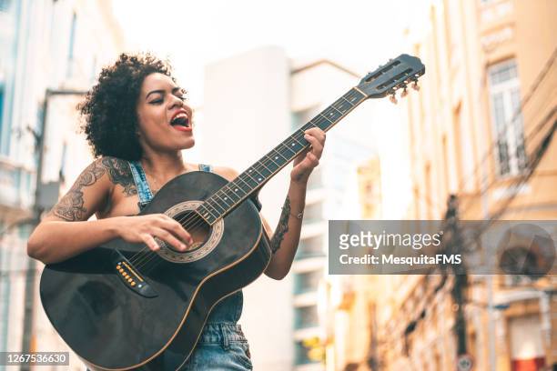 punk vrouw akoestische gitaar - zangeres stockfoto's en -beelden