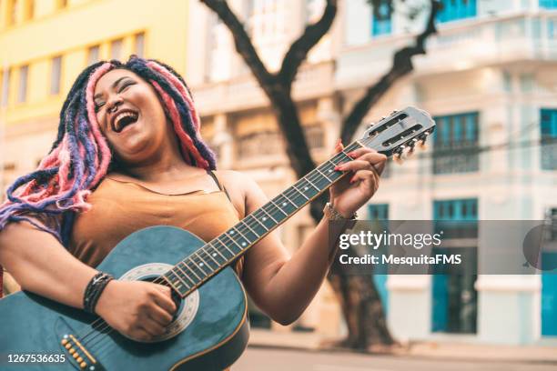 donna rastafariana che suona la chitarra acustica - cantante rock foto e immagini stock